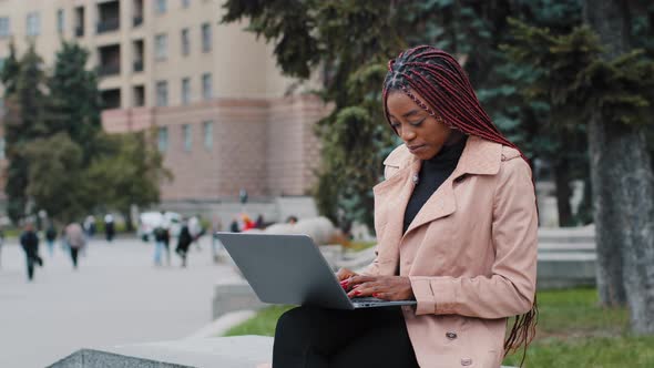 Serious African American Girl Blogger Using Laptop Sitting Outdoor Young Busy Focused Businesswoman