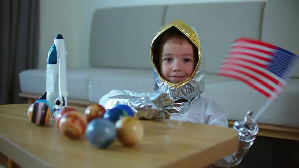 Child Plays at Home in an Astronaut Funny Portrait of a Little Boy 56 Years Old in a Toy Space Suit
