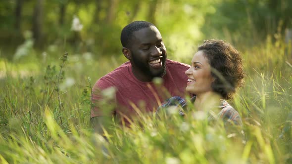 Joyful husband and thrilled wife spending free time in local park, married life