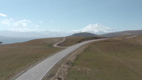 Hills and Plains in Mountain Valley Dzhily Su Elbrus. Winding Empty Asphalt Road in Highlands From