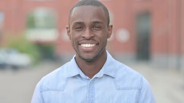 Outdoor Portrait of Young African Man Saying Yes By Shaking Head