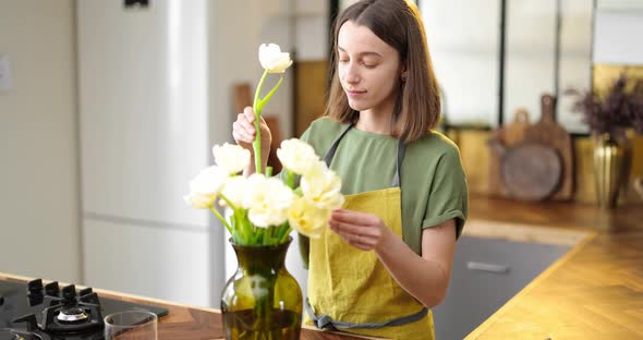 Woman Decorates Home Interior with a Bouquet of Fresh Flowers