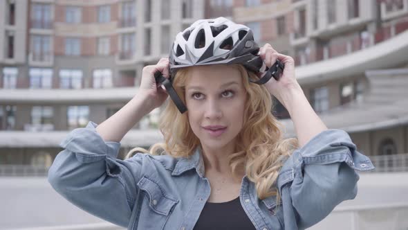 Portrait Cute Blond Woman Putting a Bike Helmet on Her Head and Riding Her Bicycle