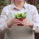 Young Woman Holds Out Pots of Flowers - VideoHive Item for Sale