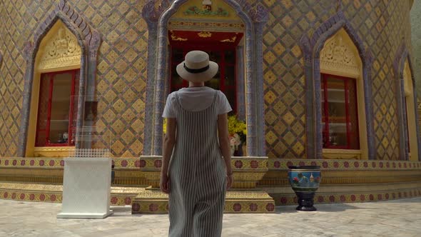 Camera follow woman traveler walking in Buddhist temple. 