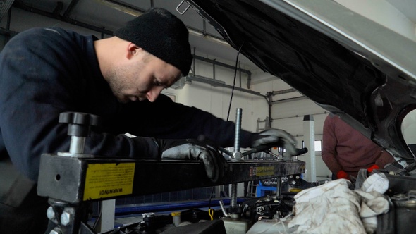 Mechanic repairing under the hood of the car