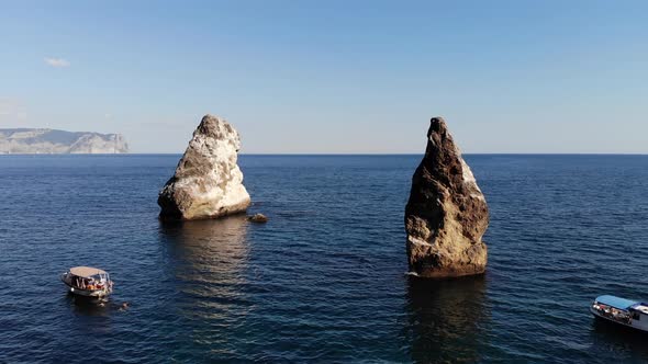 Aerial View of Tourist Boats in the Sea Bay Next To Individual Rocks and High Rocky Coast