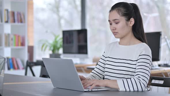 Laptop Use By Young Asian Woman Smiling at Camera