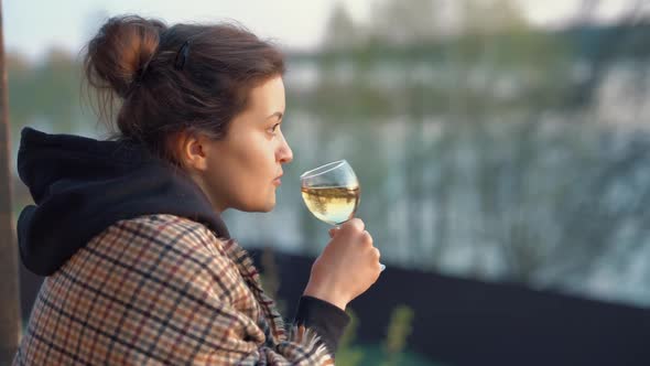 Portrait of a Beautiful Dreamy Young Woman Tasting White Wine Enjoying the Sunset on a Spring