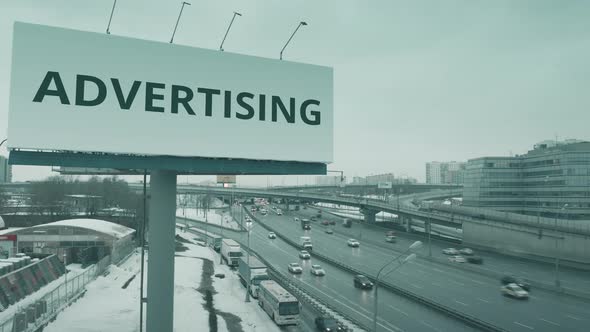 Billboard with ADVERTISING Text at Urban Highway in Winter