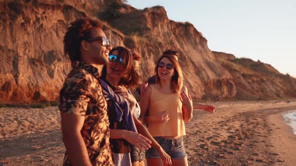 Friends Smiling Laughing Speaking Walking at Seaside at Sunrise