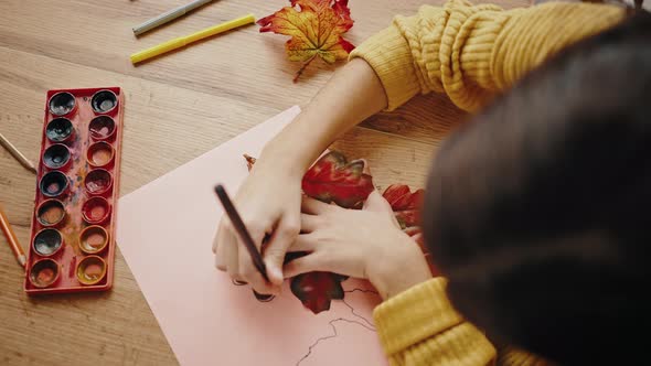 Unknown Girl Circling Oak Leaf Laying on White Sheet of Paper with Black Felttip Pen