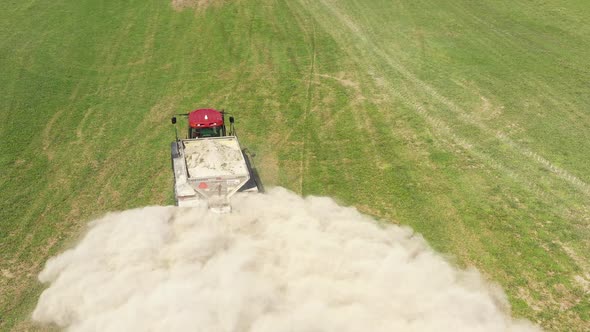 farm tractor spreading white powder closeup follow flight