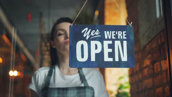 Beautiful Waitress Closing Coffee Shop in Evening Hanging Closed Sign on Door