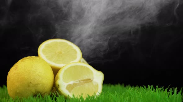 White smoke falling on organic yellow lemons on grass surface