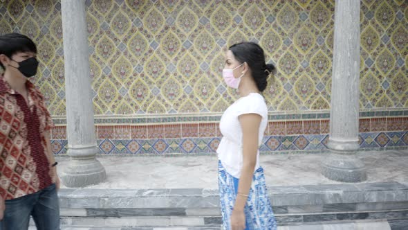 International Transgender Couple Meet and Hold Each Other's Hands Wearing Respiratory Masks in a