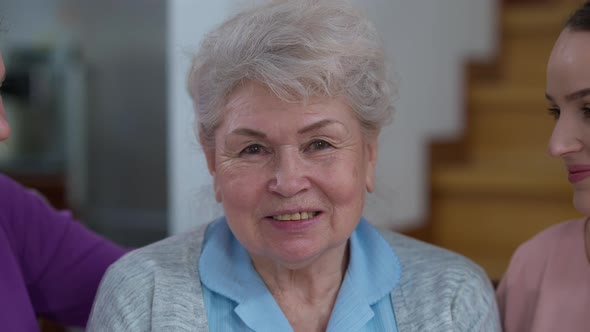 Headshot of Happy Senior Greyhaired Woman Smiling Looking at Camera As Daughter and Granddaughter