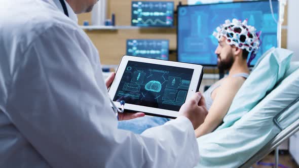 Doctor Holding Tablet with Brain Analysis in Modern Facility for Health Research