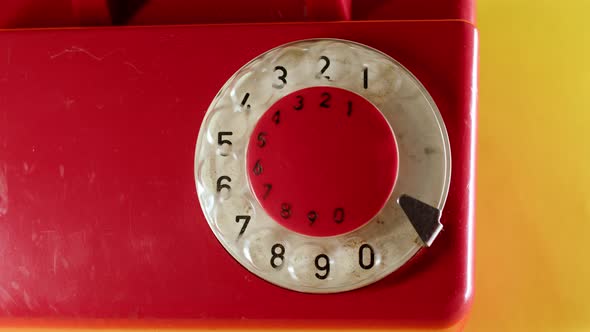 Close Up Man Hand Dialing on Old Vintage Red Dial Telephone Number 112