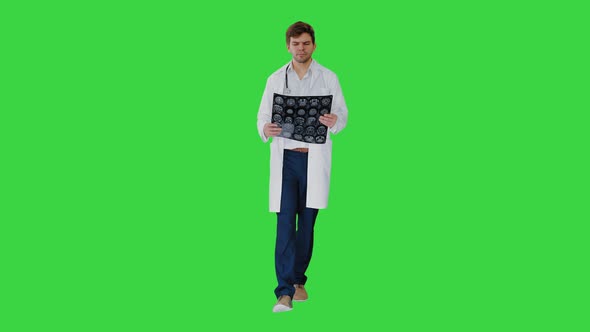 Concentrated Male Doctor Examining Computed Tomography While Walking on a Green Screen, Chroma Key.