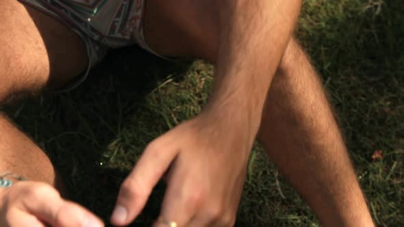 Man sitting on grass and using mobile phone