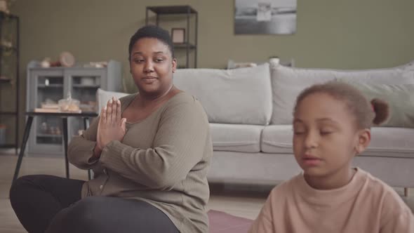 African-American Woman and Her Daughter Meditating at Home