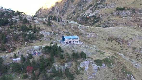 Refuge Espingo shelter cottage at Lac d'Espingo lake in Haute-Garonne, Pyrénées, France with hikers