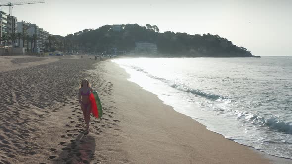 Blonde Woman in Bikini Walking on Sandy Sea Coast