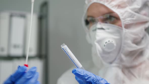 PCR Test in Laboratory Doctor Holding COVID19 Coronavirus Swab Collection Kit Wearing PPE Protective