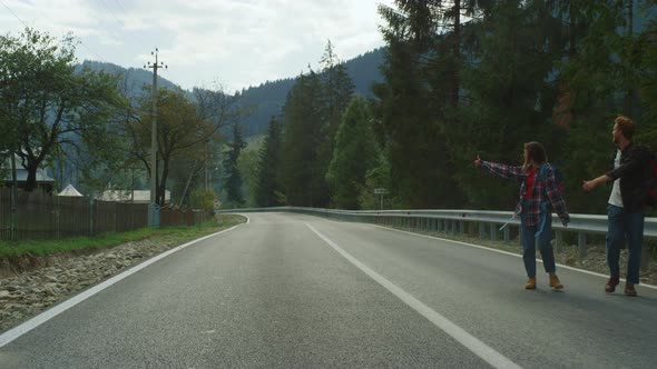 Happy Tourists Hitchhiking Car on Highway