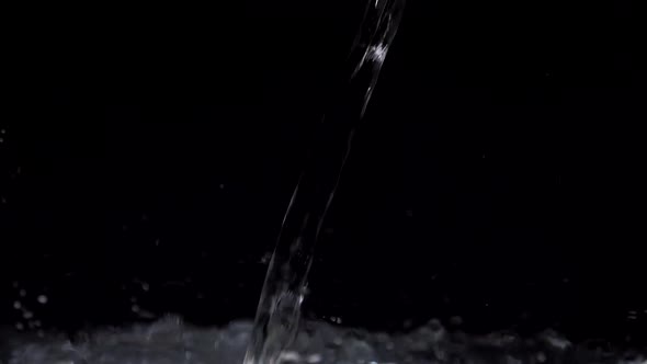 Slow Motion Stream of Water Drops Down in Aquarium on a Black Background