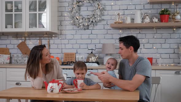 Man and Woman with Children Drinking Tea at Home