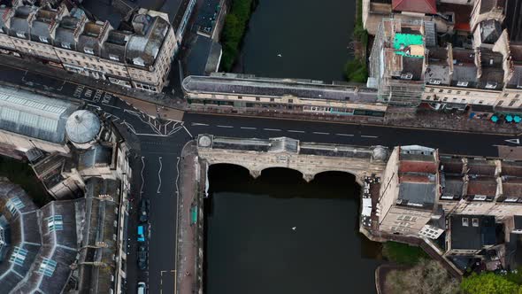 Cinematic dolly back pan up drone shot of Pulteney bridge central Bath UK