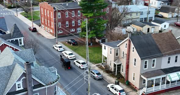 Amish Mennonite horse and buggy in small town America. Aerial tracking shot through small town in US