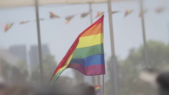 LGBTQ rainbow flag waving in slow motion during the main party in a pride parade