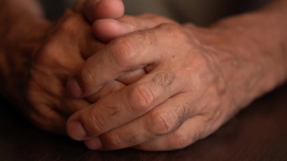 Hands of the Older Man on the Table in Closeup
