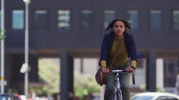 African american woman riding bicycle in street