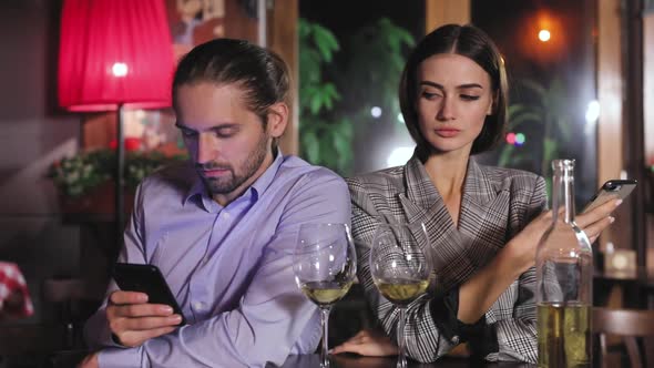 Communication Problem. People Using Phone On Date At Restaurant