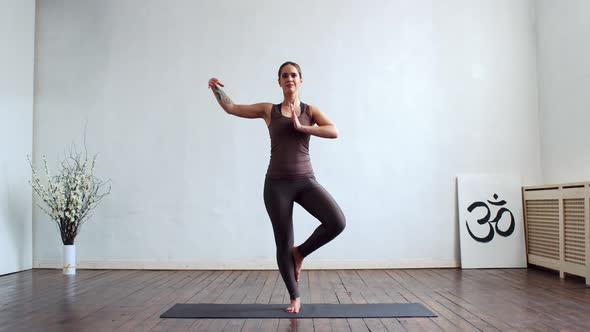 Young and fit woman practicing yoga indoor in the class.