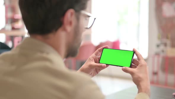 Young Man Looking at Smartphone with Chroma Screen