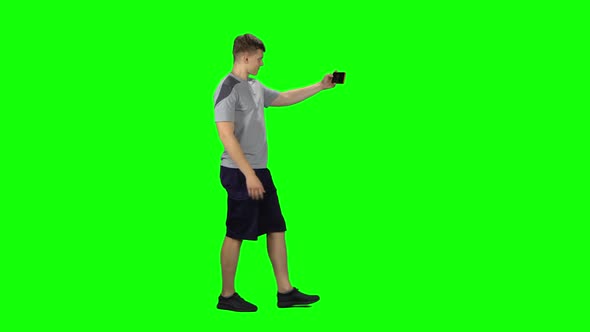 Smiling Guy Goes and Texting on the Phone, Chroma Key. Profile Side View