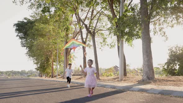 Asian two brothers happy children boy and girl with a kite running to fly