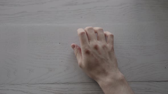 POV Shot of Man Finger Tap on White Oak Table with Window Light