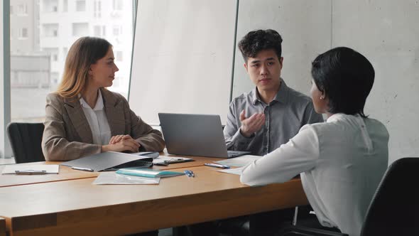 Multiracial Business Partners Colleagues Sitting at Table in Office Meeting Insurance Agent Asian