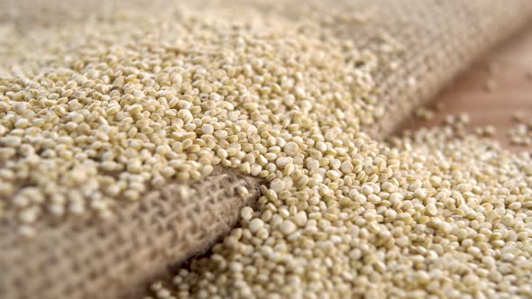 Raw quinoa seeds on a rough rustic burlap on a wooden surface. Macro