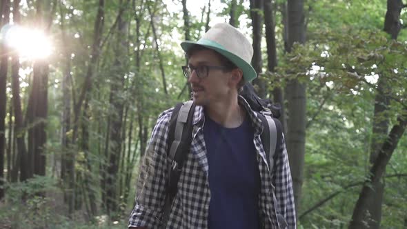 A Tourist Walks Through a Dense Green Forest