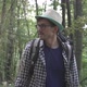 A Tourist Walks Through a Dense Green Forest - VideoHive Item for Sale