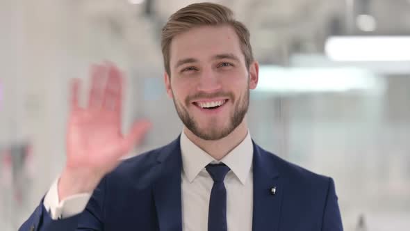 Young Businessman Waving Welcoming