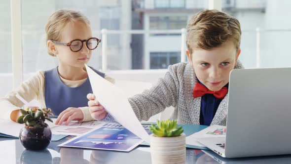 Kids as business executives discussing over laptop 4k