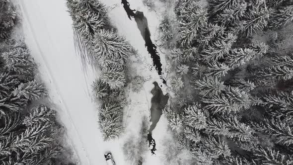 Aerial Birdseye View Over Forest River And Road In Winter